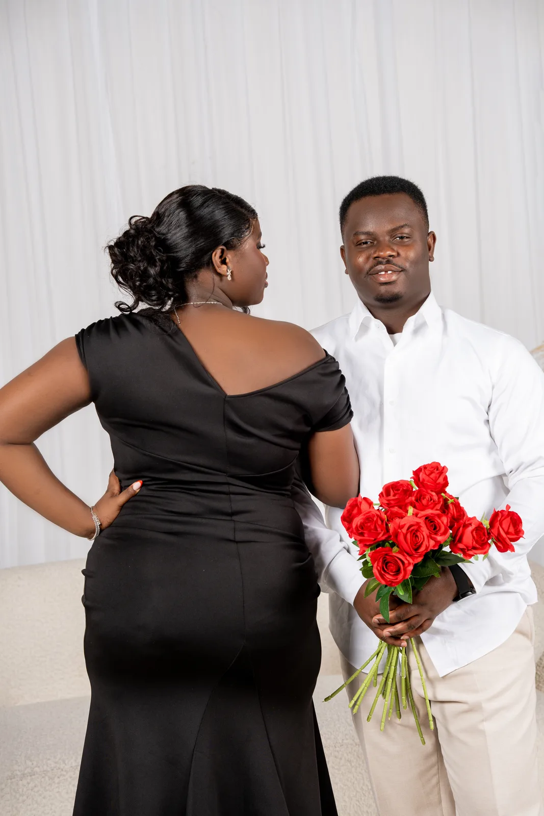 The couple, roses behind their backs